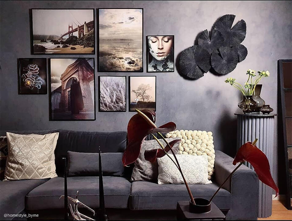 Salon en chelle de gris - mur d'images au-dessus d'un canap en velours